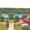 Vista su una piscina circondata da alberi e palme.