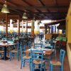 Ristorante all'aperto con tavoli e sedie blu.