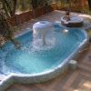 Piscina piccola con cascata centrale e vasca idromassaggio.