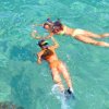 Due persone che fanno snorkeling in acqua cristallina.