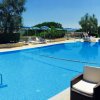 Piscina con colonne blu e sedie bianche.