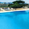 Piscina con vista su colline e lettini bianchi.