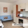 Soggiorno con angolo cottura e divano.