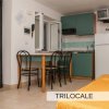 Cucina con tavolo e sedie, accanto a un letto.
