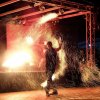 Artista di strada con fiamme e scintille.