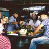 Quattro persone brindano con boccali di birra in un locale a tema western.