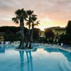 Piscina con palme al tramonto.