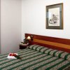 Camera con letto verde a righe e quadro.