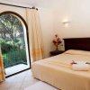 Camera con letto beige e vista sul giardino.