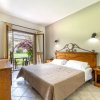 Camera con letto beige e porta-finestra aperta.